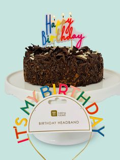 a birthday cake sitting on top of a white plate next to a happy birthday sign