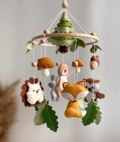 a mobile with various stuffed animals hanging from it's sides and trees on the other side