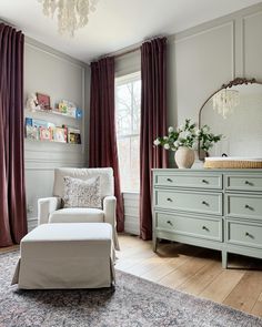 a living room filled with furniture and a chandelier hanging from the ceiling next to a window