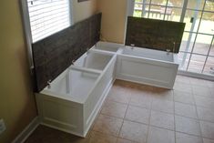 a bathtub sitting in the middle of a room next to a sliding glass door