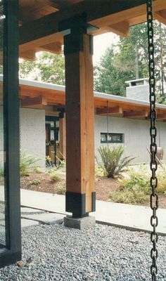 a wooden structure with chains hanging from it's sides and a building in the background