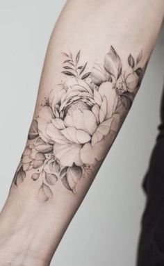 a black and white flower tattoo on the arm