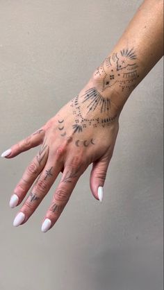 a woman's hand with tattoos on it