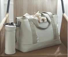 a large white bag sitting on top of a wooden chair next to a stuffed animal