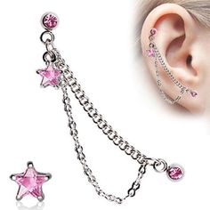 a pair of ear piercings with pink crystal stars and chain attached to the end