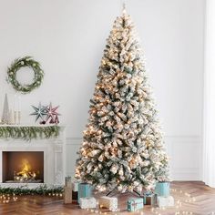 a decorated christmas tree in front of a fireplace with presents on the floor next to it