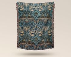 an intricately designed piece of cloth with fringes on the edges and in blue tones