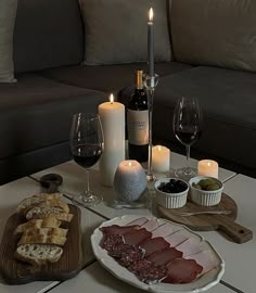 a table with wine, bread and candles on it