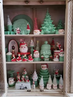 a shelf filled with christmas decorations and santa clause figurines