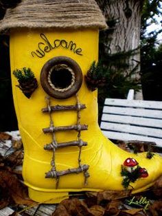 a yellow rain boot with the word welcome painted on it's side, sitting in leaves