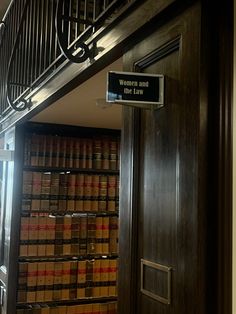 an open door leading to a library with books on shelves and a sign that reads women and the law