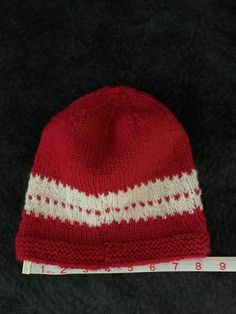 Beautiful red and white winter stocking cap. Hand knit with a wool mix yarn so it will keep your head warm and toasty on cold winter days. This stocking cap has quite a bit of stretch and will comfortably fit most people. Red Knitted Beanie For Winter, Red Knitted Winter Beanie, Red Knit Winter Hat, Red Knitted Hat For Cold Weather, Casual Red Yarn Beanie, Cozy Red Knitted Hat, Cozy Red Knitted Beanie, Red Bonnet For Winter, One Size Fits Most, Red Winter Bonnet (one Size Fits Most)