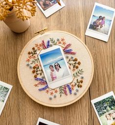 a table topped with pictures and photos on top of a wooden table next to a vase filled with flowers