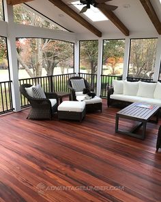 an outdoor living room with wood flooring and white furniture