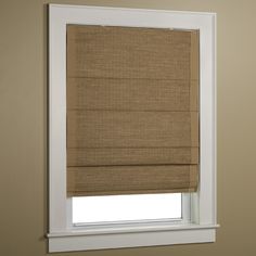 a tan roman blind hanging on the side of a window