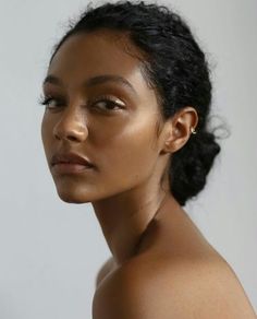 a close up of a woman with dark hair and no shirt on, looking off to the side