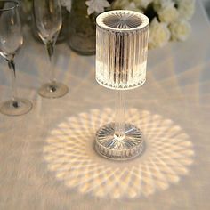 a table topped with two wine glasses and a lamp