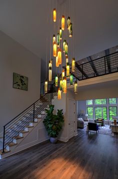 a chandelier made out of bottles hanging from the ceiling in a living room