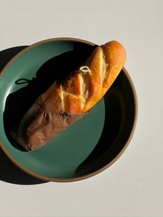 a piece of bread sitting on top of a green plate