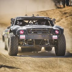 an off - road vehicle driving down a dirt road