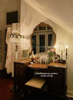 a vanity with a mirror and candles on top of it in a room that has a slanted ceiling