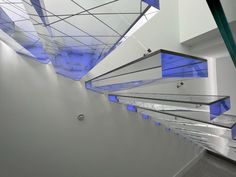 an empty hallway with blue lights on the ceiling