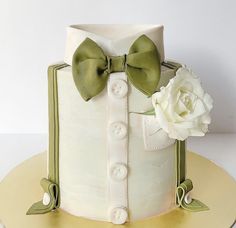 there is a white cake with green bows on it and a flower in the middle