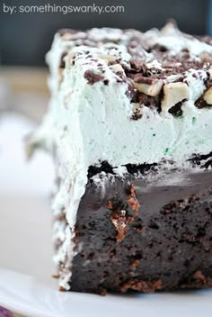 a close up of a piece of cake on a plate with chocolate and white frosting