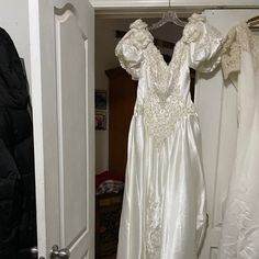 a white dress hanging on a rack in a closet