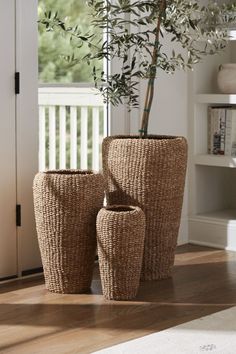 two planters sitting next to each other on a wooden floor