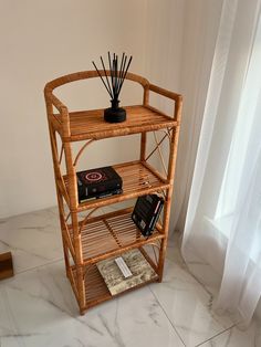 a bamboo shelf with candles and books on it