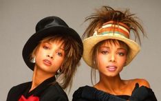 two young women wearing hats and posing for the camera