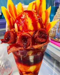 a glass filled with fries and ketchup on top of a table