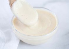 a wooden spoon in a glass bowl filled with cream