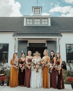 a group of women standing next to each other in front of a house