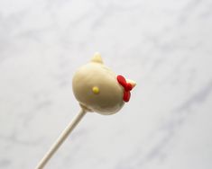 a close up of a cake on a stick with a hello kitty head sticking out of it