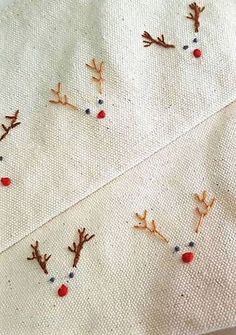 embroidered reindeer heads on white fabric with red beads