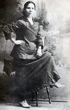 an old photo of a woman sitting in a chair