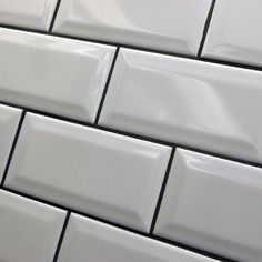 a white tile wall with black lines on it