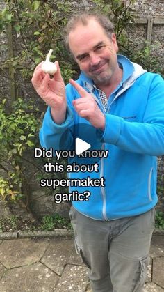 a man in a blue jacket holding up a piece of food with the caption did you know this about supermaket garlic?