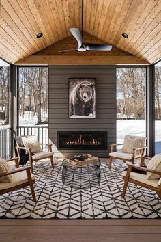 a living room filled with furniture and a fire place in front of a wooden ceiling