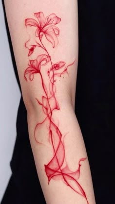 a woman's arm with red ink on it and a flower in the middle