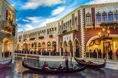 two gondolas in the middle of a canal at dusk