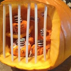 a pumpkin that has been carved to look like it is in a basket with candy inside