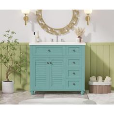 a bathroom with green and white walls, a blue vanity sink and a round mirror on the wall