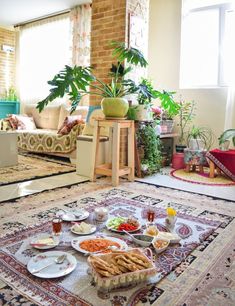 a living room filled with furniture and lots of food on top of a rug in front of a window