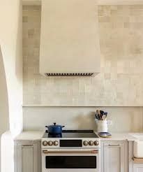 a stove top oven sitting inside of a kitchen next to a wall mounted range hood