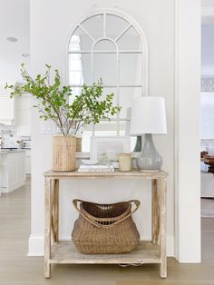 a living room with a table and mirror on the wall