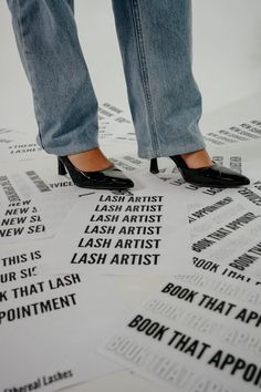 a woman standing on top of a pile of paper with words written in black and white