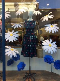 a mannequin in front of a window with blue and white flowers